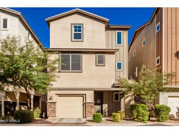 Tan three-story home with two-car garage and landscaping at 750 W Flintlock Way, Chandler, AZ 85286