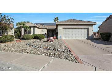 Single-story home with a two-car garage and landscaped front yard at 15938 W Summerwalk Dr, Surprise, AZ 85374