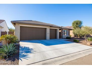 Two-car garage, desert landscaping, and neutral-colored exterior at 16925 W Virginia Ave, Goodyear, AZ 85395