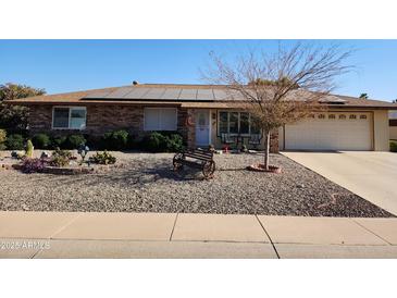 Ranch-style home with solar panels, desert landscaping, and a two-car garage at 12411 N Cantata Ct, Sun City, AZ 85351