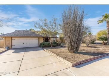 House exterior with a garage and desert landscaping at 1801 E Aire Libre Ave, Phoenix, AZ 85022