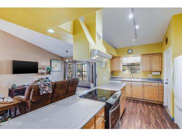 Bright kitchen with wood cabinets, granite countertops, and island at 1801 E Aire Libre Ave, Phoenix, AZ 85022