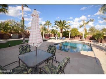 Inviting backyard pool surrounded by a patio with desert landscaping and comfortable seating area at 31689 N Blackfoot Dr, San Tan Valley, AZ 85143