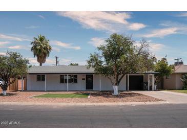 White single story house with a landscaped front yard and a two car garage at 3426 W Elm St, Phoenix, AZ 85017