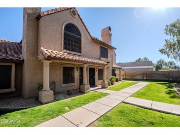 Two-story stucco condo with Spanish tile roof, walkway, and grassy yard at 3491 N Arizona Ave # 54, Chandler, AZ 85225