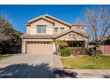 Two-story house with tan exterior, landscaped lawn, and attached garage at 4444 E Peach Tree Dr, Chandler, AZ 85249