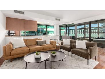 Modern living room features a leather sofa, two armchairs, and a coffee table at 4808 N 24Th St # 921, Phoenix, AZ 85016