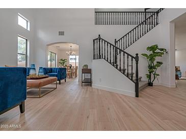 Bright living room with high ceilings, hardwood floors, and stylish blue velvet furniture at 6909 N 71St Dr, Glendale, AZ 85303