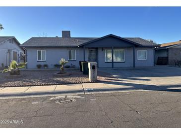 Gray single story home with landscaped front yard and a covered porch at 7217 W Claremont St, Glendale, AZ 85303