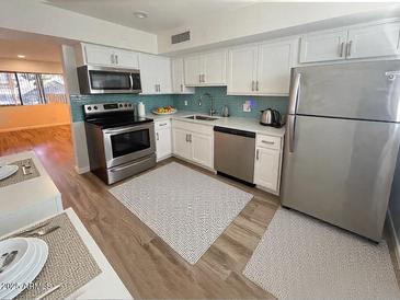 Modern kitchen featuring stainless steel appliances and white cabinetry at 749 E Montebello Ave # 130, Phoenix, AZ 85014