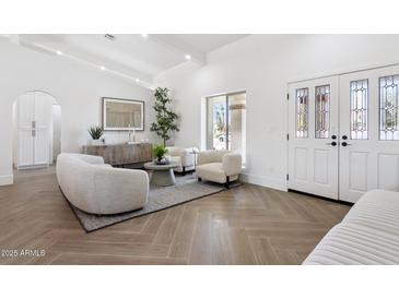Bright living room featuring stylish seating, herringbone floors, and plenty of natural light at 9031 N 83Rd Way, Scottsdale, AZ 85258