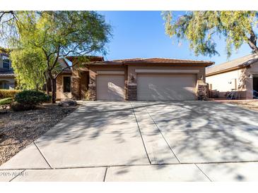 House exterior with a three-car garage and landscaped yard at 10022 N Erin Ct, Waddell, AZ 85355