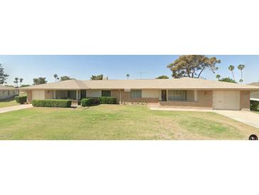 Brick ranch home with a large yard and mature trees at 10025 W Shasta W Dr, Sun City, AZ 85351