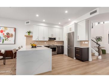 Modern kitchen with white and dark wood cabinets, quartz countertops, and stainless steel appliances at 10222 E Southwind Ln # 1026, Scottsdale, AZ 85262