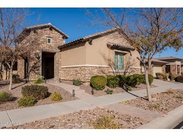 Tan two-story house with stone accents and landscaping at 10434 E Texas Ave, Mesa, AZ 85212