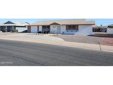 Ranch style home with a large front yard and driveway at 10615 N 102Nd Dr, Sun City, AZ 85351