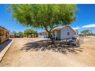 Ranch-style house with a large tree in the front yard at 21543 W Church Ave, Wittmann, AZ 85361