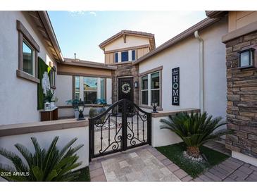 Inviting front courtyard with ornate gates, landscaping, and a charming entrance at 2351 E Cherrywood Pl, Chandler, AZ 85249