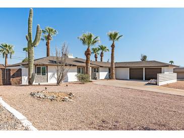 White mid-century modern home with desert landscaping and two-car garage at 2826 E Victor Hugo Ave, Phoenix, AZ 85032