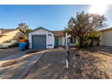 Cute one-story home with a gray garage door and turquoise front door at 3009 W Potter Dr, Phoenix, AZ 85027