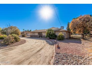 Ranch style home with long driveway and mature landscaping at 4321 W Greenway Rd, Glendale, AZ 85306