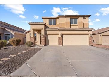 Two-story house with beige exterior, stone accents, and a two-car garage at 46108 W Tulip Ln, Maricopa, AZ 85139