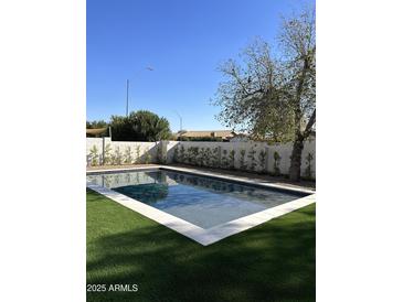 Inviting rectangular pool with artificial turf and a modern design at 6017 E Beck Ln, Scottsdale, AZ 85254