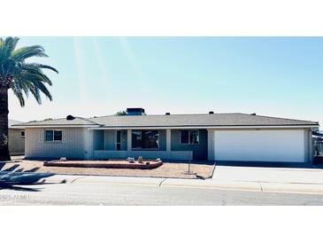 Charming single-story home featuring a well-maintained front yard and a two-car garage at 6449 E Dodge St, Mesa, AZ 85205