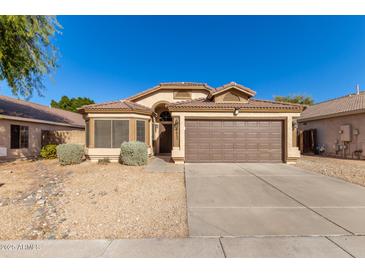 One-story house with brown garage door and desert landscaping at 6612 W Paso Trl, Phoenix, AZ 85083