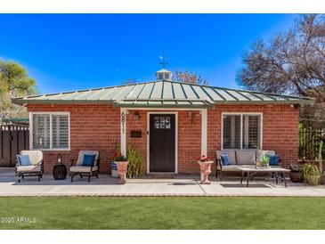 Charming brick home with a cozy front porch seating area and green lawn at 6811 N 11Th Ave, Phoenix, AZ 85013