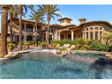 Resort style pool and spa with swaying palms perfect for outdoor entertaining in this luxury home at 6876 S Star Dr, Gilbert, AZ 85298