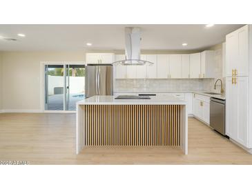 Modern kitchen with white cabinets, stainless steel appliances, and a large island at 7432 E Latham St, Scottsdale, AZ 85257