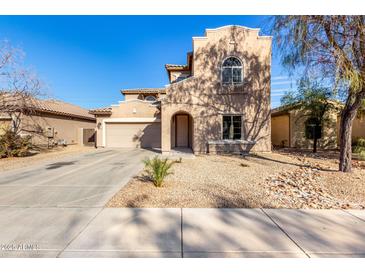 Two-story house with Spanish-style architecture, featuring a large garage and landscaped front yard at 10116 W Luxton Ln, Tolleson, AZ 85353