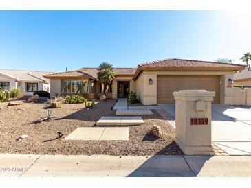 Single-story home with desert landscaping and a two-car garage at 10329 E Sunridge Dr, Sun Lakes, AZ 85248