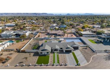 Aerial view of a modern home with a pool and landscaped yard, in a residential neighborhood at 12075 N 76Th Ct, Scottsdale, AZ 85260