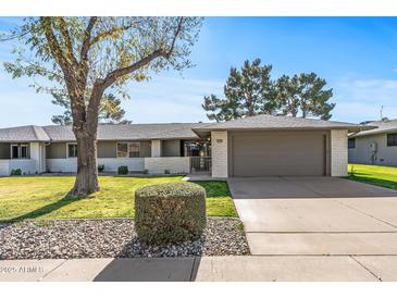 Single-level home with a two-car garage and well-manicured lawn at 12539 W Shadow Hills Dr, Sun City West, AZ 85375