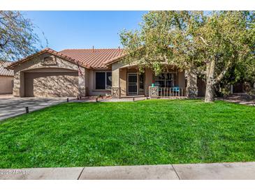 Single-story home with a well-manicured lawn and a covered porch at 20838 N 101St Dr, Peoria, AZ 85382