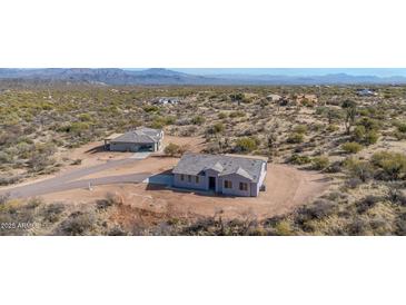 Aerial view of two new homes nestled in a desert landscape with mountain views at 35810 E 138Th Pl, Scottsdale, AZ 85262