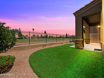 The spacious backyard features well manicured artifical turf and a wrought iron fence with beautiful golf course views at 6202 E Mckellips Rd # 83, Mesa, AZ 85215