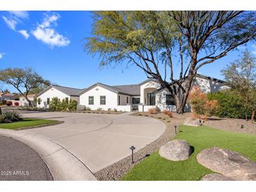 Stunning curb appeal of a single story home with a large driveway and manicured landscaping at 6644 E Cholla Dr, Paradise Valley, AZ 85253