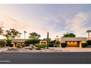 Stunning desert home with a charming courtyard and wooden garage doors at 8408 E La Senda Dr, Scottsdale, AZ 85255