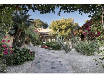 Landscaped front yard with a stone pathway leading to a beautiful Spanish-style home at 8408 E La Senda Dr, Scottsdale, AZ 85255