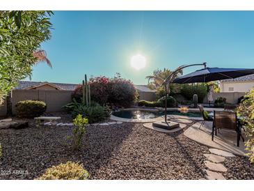 Relaxing backyard oasis with a sparkling pool and patio furniture at 9345 E Hobart St, Mesa, AZ 85207