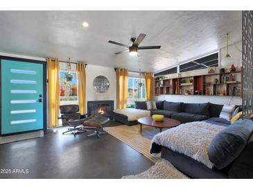 Mid-century modern living room with sectional sofa, fireplace, and large windows at 1125 E Northview Ave, Phoenix, AZ 85020