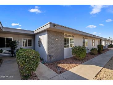 Inviting exterior of a condo building with landscaping and walkway at 13606 N 108Th Dr, Sun City, AZ 85351