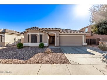 One-story house with tan exterior, tile roof, and two-car garage at 25583 W Beth Dr, Buckeye, AZ 85326