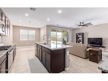 Open kitchen with an island, stainless steel appliances, and a view of the living room at 3317 N 300Th Dr, Buckeye, AZ 85396