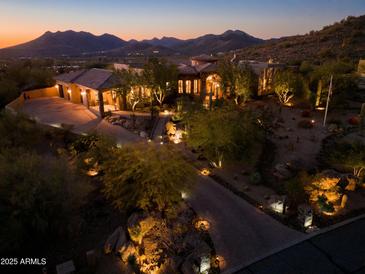 Luxury estate at night with mountain views, long driveway, and mature landscaping at 36050 N Summit Dr, Cave Creek, AZ 85331