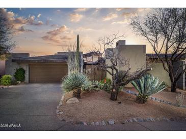 Desert landscape surrounds this contemporary home with a large garage and inviting entryway at 39565 N 107Th Way, Scottsdale, AZ 85262