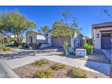 Single story home with neutral exterior, two-car garage, and landscaped front yard at 5015 S Quantum Way, Mesa, AZ 85212